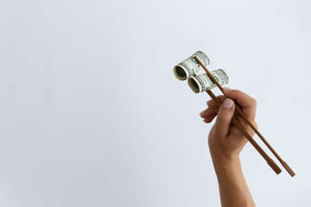 Rolled 200 dollars with timber chopstick on a white with a place for ext.の写真素材