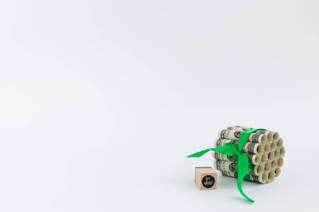 100 dollars tied with green ribbon and wooden cube with words for you on it.の写真素材