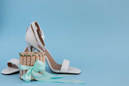 Women high heel shoes with Ukrainan money tied with a gift ribbon.の写真素材