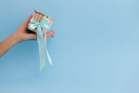 Female hand holding Ukrainian money in rolls tied with a gift ribbon.の写真素材
