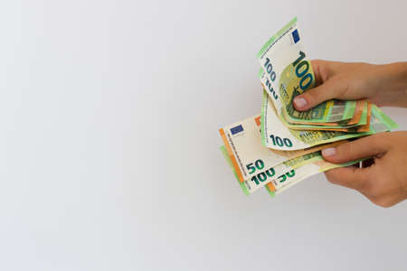 Hands holding euro money or giving money. On a white background with copy space.