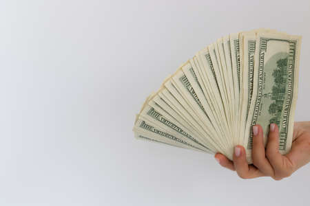 Female hand holding USA dollars. On a white background with a copy space.