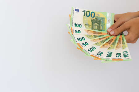 Hand holding euro money or giving money. On a white background with copy space.の写真素材