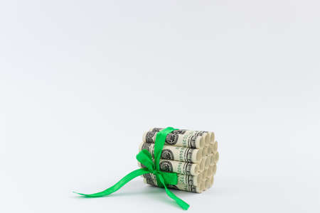 Banknotes of 100 dollars in rolls tied with green ribbon. Money gift.の写真素材