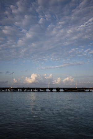 Morning seascape. The pier, the sea and soft clouds above it.の写真素材