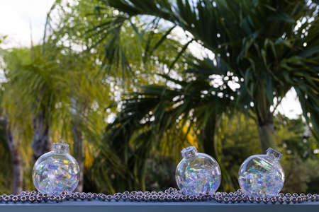 Christmas shiny balls on a palm leaves background.の写真素材