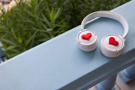 Headphones with hearts are on a balcony railing.の写真素材