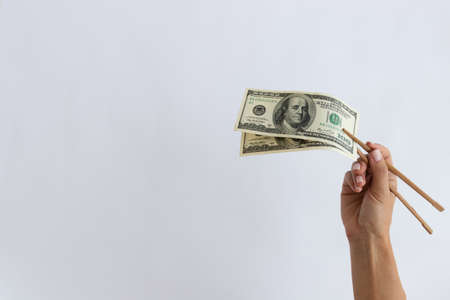 American dollars in timber chopstick on a white background.の写真素材