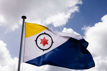 Bonaire flag flying in the wind on the blue sky background.の写真素材