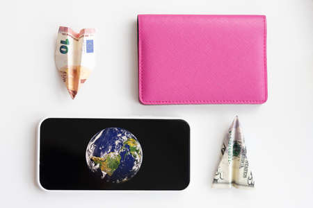 Passport, smartphone and planes made of dollar and euro bills. Selective focusの写真素材