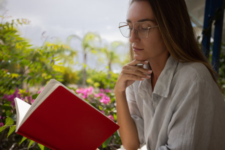 Young woman reading notebook and taking notes.の写真素材