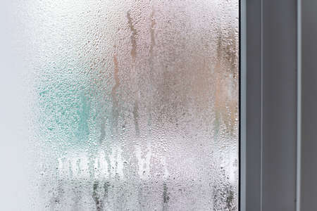Glass with condensation, natural water drops on glass, high humidity. Selective focus, blurred.