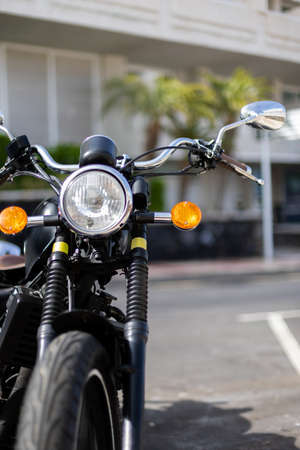 Motorbike is parked on a parking lot outside.
