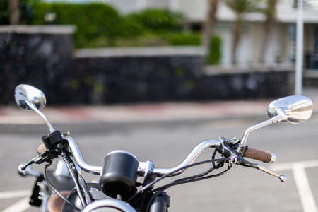 Handlebar of motorbike closeup. Motorbike is parked on the street.の写真素材