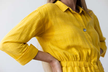 Woman in yellow dress with wet armpits. Closeup.