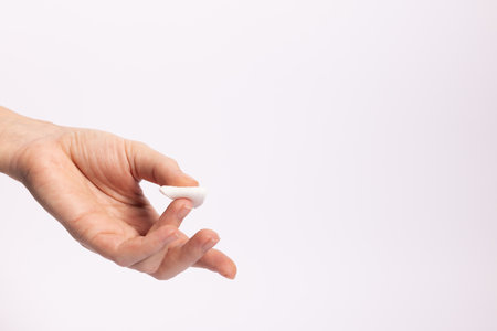 Woman finger with cotton swab after taking blood test. On a white background with a copy space.の写真素材