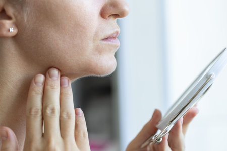 Woman in front of the mirror checking her lymph nodes. Woman has a sore throat.