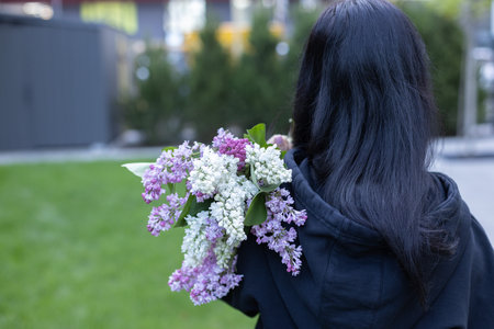 Woman with bouquet of lilac flowers. Rear view. Closeup.の写真素材