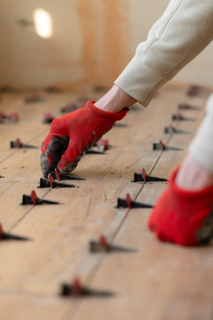 Man Installing Tile Levelling System Components. Closeup, selective focus.の写真素材