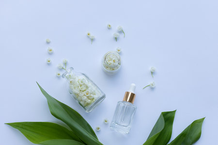 Glass bottle of lily of the valley essential oil with fresh flowersの写真素材