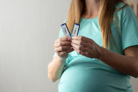 Pregnant woman holding rapid tests for hepatitis. Negative tests for hepatitis. Closeupの写真素材