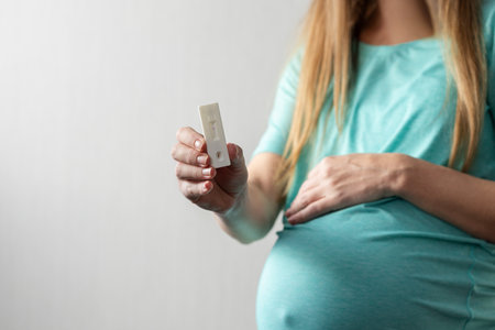 Pregnant woman holding rapid test for HIV with negative marks.の写真素材