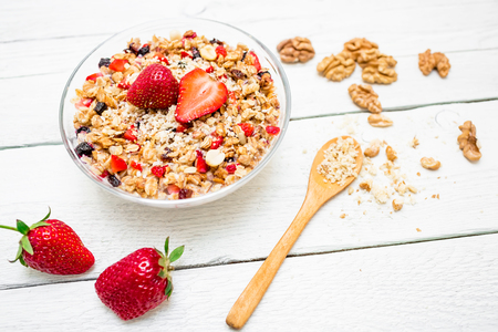 Oatmeal porridge with blueberries, strawberries and muesli on white wood background. Flat lay. Top view.の写真素材