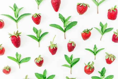 Strawberries and mint leaves on white background. Flat lay.Top view. Colorful pattern made of berriesの写真素材