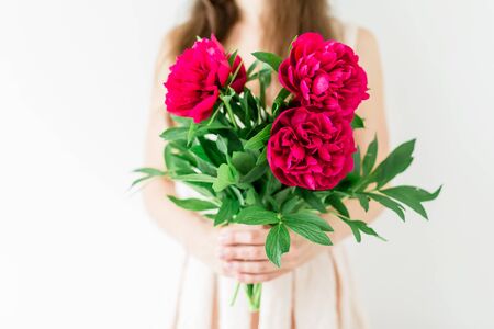 Happy young woman holding in hands peony bouquet. Sweet traditional momentの写真素材