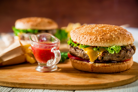 Classic hamburger with beef and tomato sauce on wooden plate. Tasty food conceptの写真素材