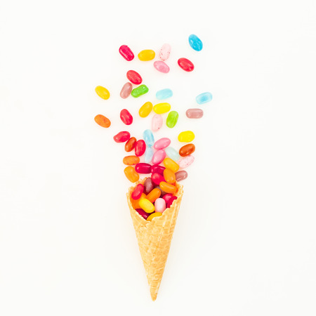 Waffle cone with colorful bright candy on white background. Flat lay, top viewの写真素材
