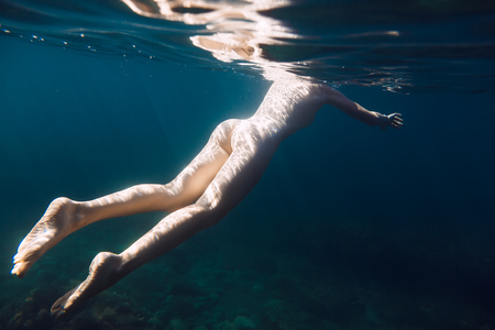 Beautiful woman with perfect body swimming in the sea is underwaterの写真素材