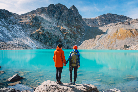 Couple of look looks at the lake. Honeymoon in Alps. Beautiful turquoise lake in the mountains.の写真素材