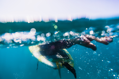 Surfer rowing on the surfboard. Surfer and oceanの写真素材