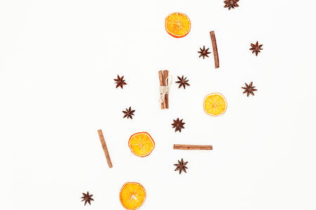 Pattern made of cinnamon, anise and dried oranges on white background. Flat lay, top view. Christmas or New Year concept.の写真素材