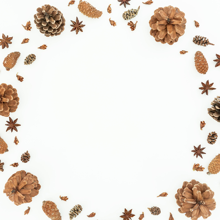 Christmas or New Year round frame with pine cones and anise on white background. Flat lay, top view.の写真素材