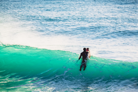 Surfer in wet suit and blue ocean wave. Surfing in the blue oceanの写真素材