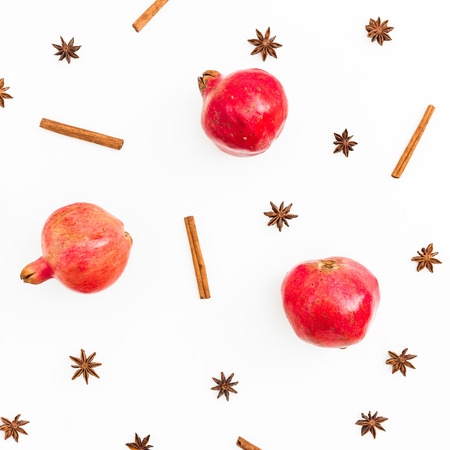 Red delicious garnet, cinnamon and anise on white background. New year concept. Flat lay. Top viewの写真素材
