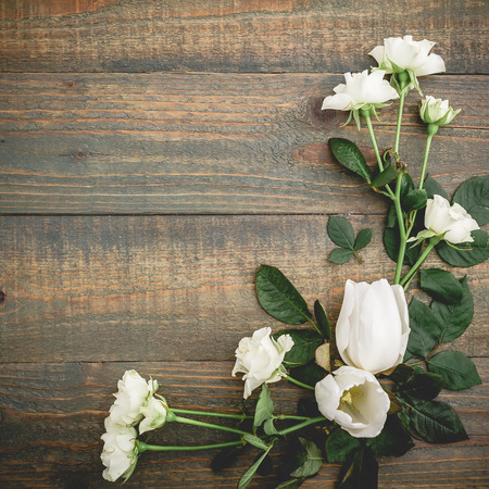 Floral composition of white tulips and rose on wooden background. Flat lay, top view.の写真素材