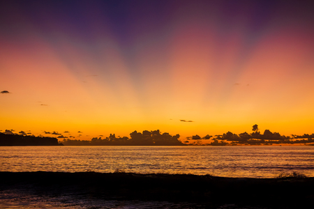 Wave at bright sunset or sunrise in the ocean. Ocean with warm sunset colorsの写真素材