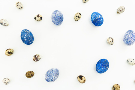 Stylish Frame background with quail and blue easter eggs with copy space for text isolated on white background. Flat lay, Top view. Easter concept.の写真素材