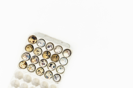Quail eggs in box on white background. Flat lay, top view. Easter concept.の写真素材