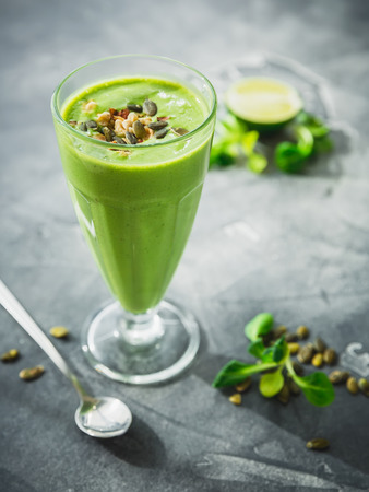 Healthy green smoothie with spinach, banana and pumpkin seeds.の写真素材