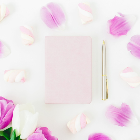 Pink tulips flowers and marshmallow with dairy and pen on white background. Flat lay, Top view. Tulip flower and candyの写真素材