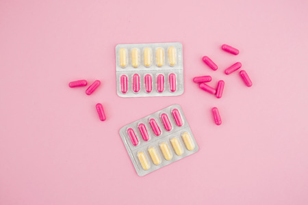 Healthy composition with vitamins pills on pink background. Flat lay, top view.の写真素材