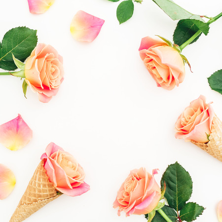 Floral frame with roses, buds and cones on white background. Flat lay, top view. Spring background