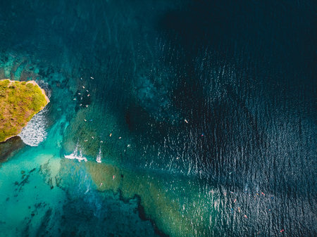 Tropical ocean with waves and surfer in Bali. Aerial view.
