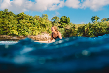 Beautiful surfer woman on longboard. Surfer and ocean wave