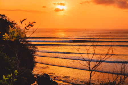 Colorful warm sunset or sunrise with ocean and perfect waves fo surfingの写真素材