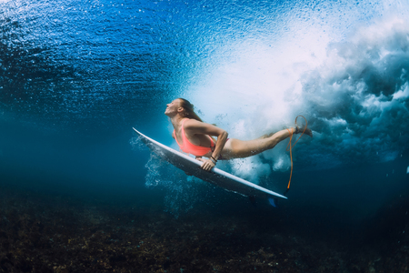 Attractive surfer woman dive underwater with under wave.の写真素材